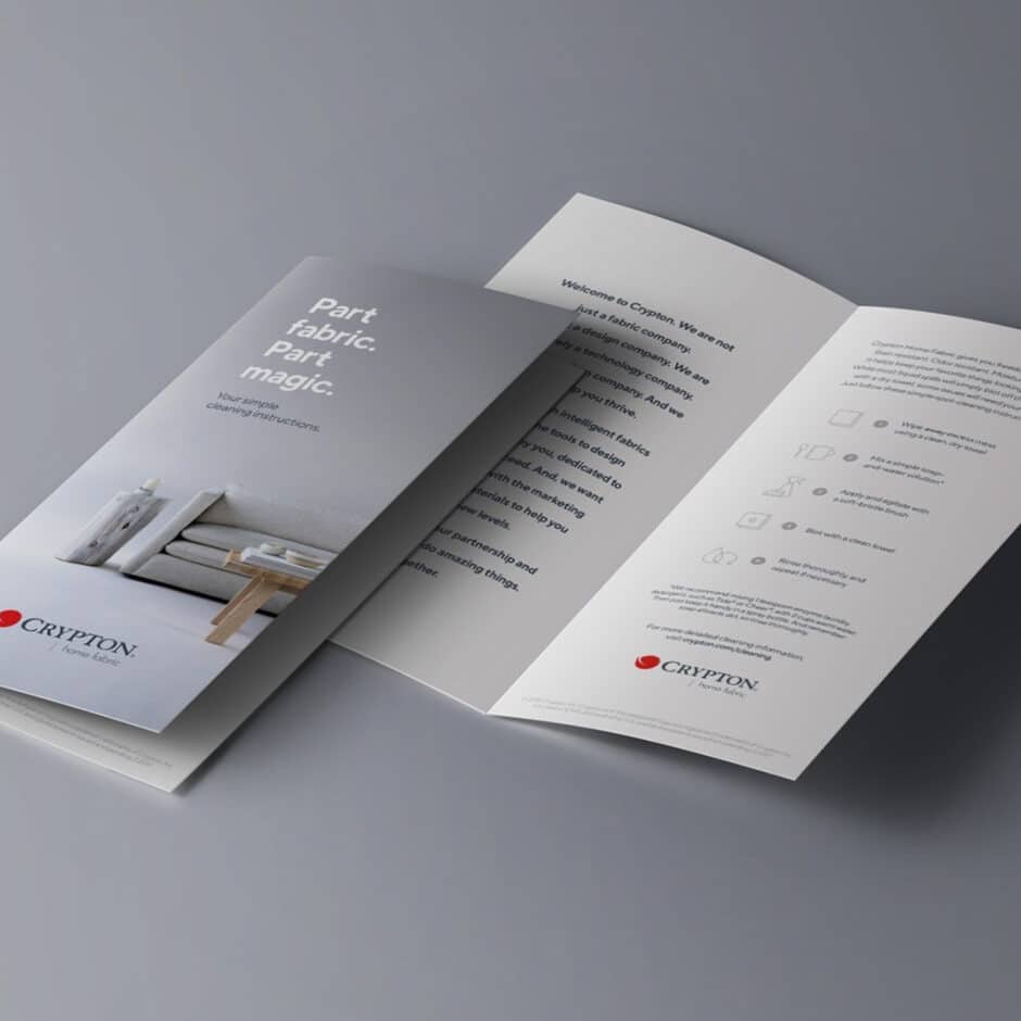 Three-panel brochure on a gray surface with soft, elegant design. Cover shows a minimalist living room and text, 'Part fabric, part magic.' The open panels contain detailed text and icons related to fabric care and the company, Crypton Fabric, conveying a professional and innovative tone.