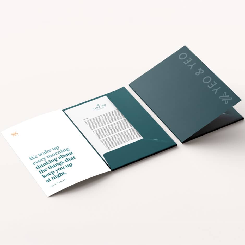 Dark teal folder partially open, revealing a document inside and text on the inner pocket. Elegant and professional stationery on a light background.