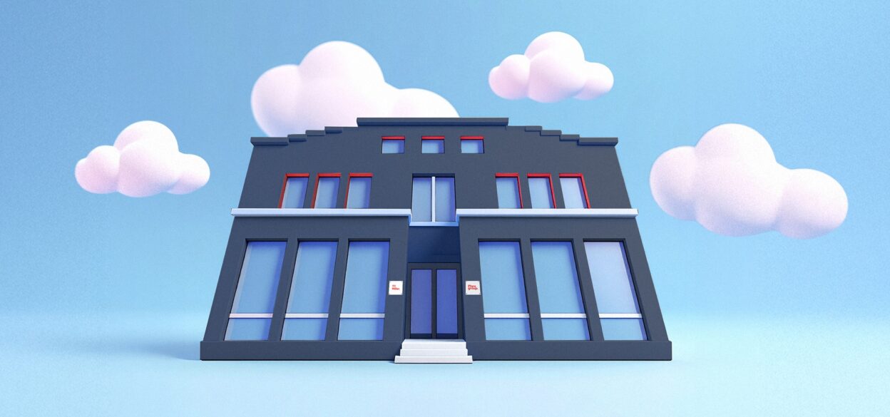 A stylized, dark gray building with large blue windows and red trim sits against a backdrop of fluffy white clouds and a light blue sky.